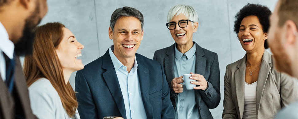 six office workers laughing together