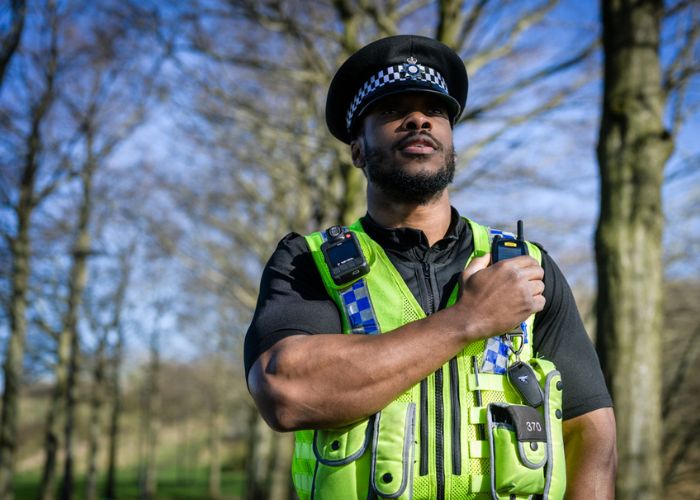 police officer in a hat pressing radio