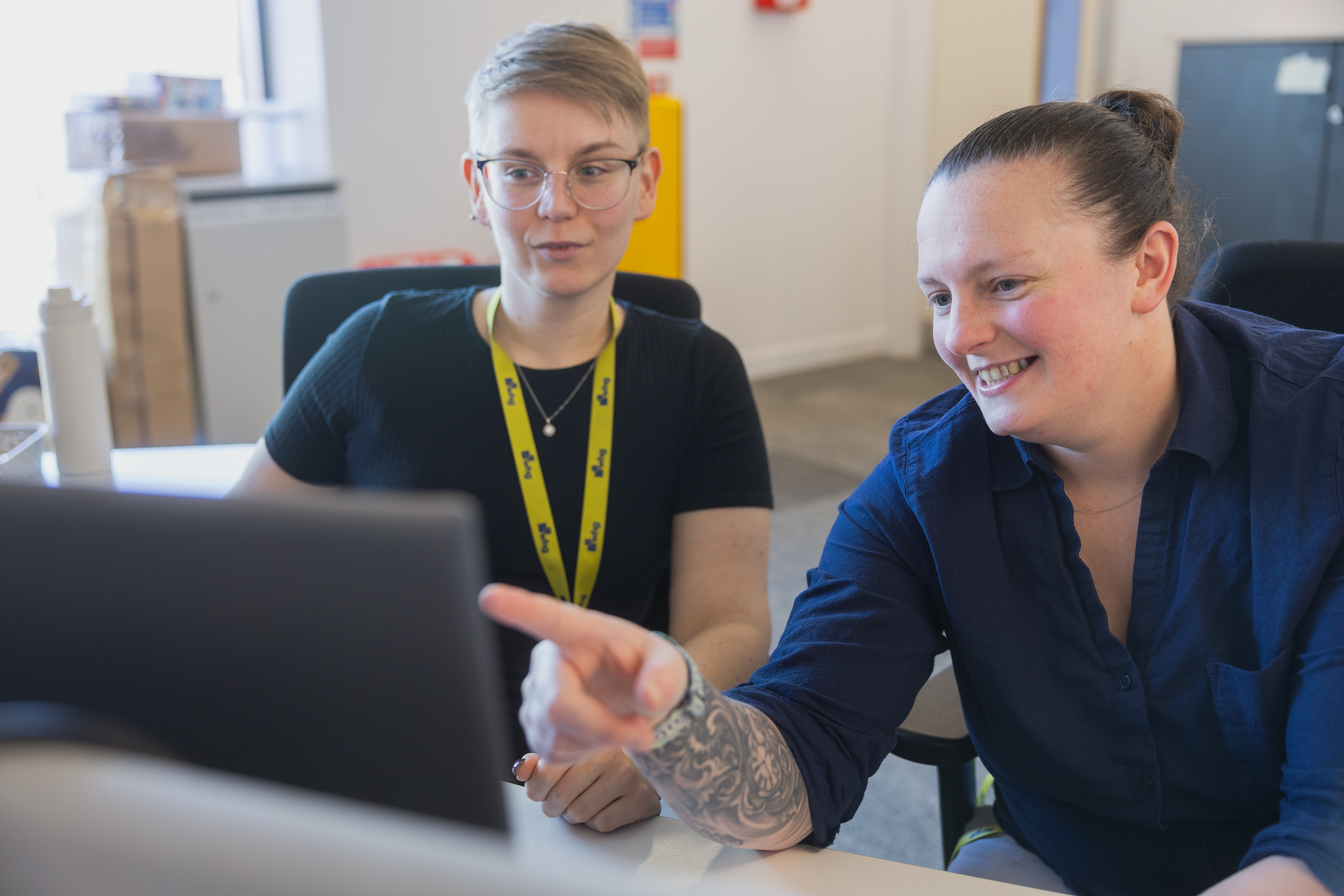 Two people looking at a computer at a desk