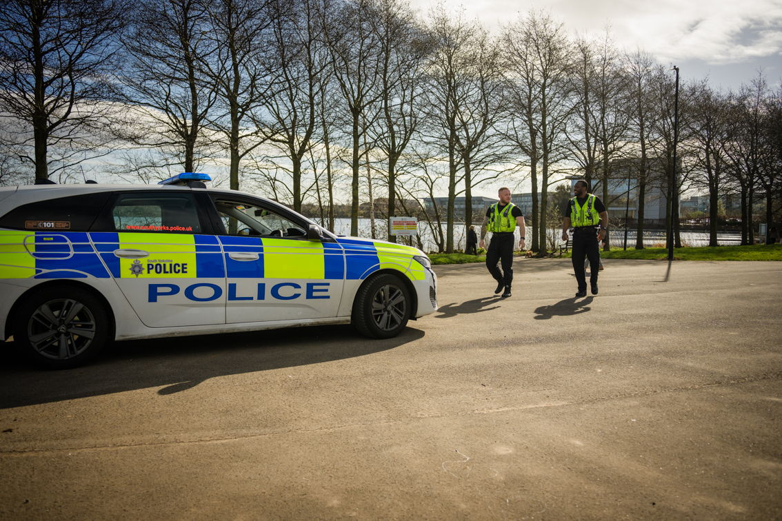Police inspectors walking towards police car