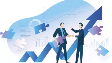 Two people shaking hands with charts and puzzle pieces in the background.