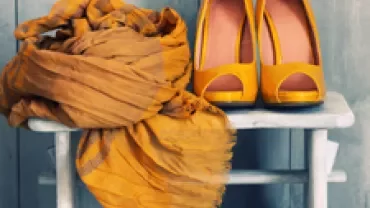Yellow scarf and high heels on a wooden stool.