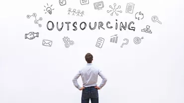 Person looking at the word 'Outsourcing' with various icons on white background.